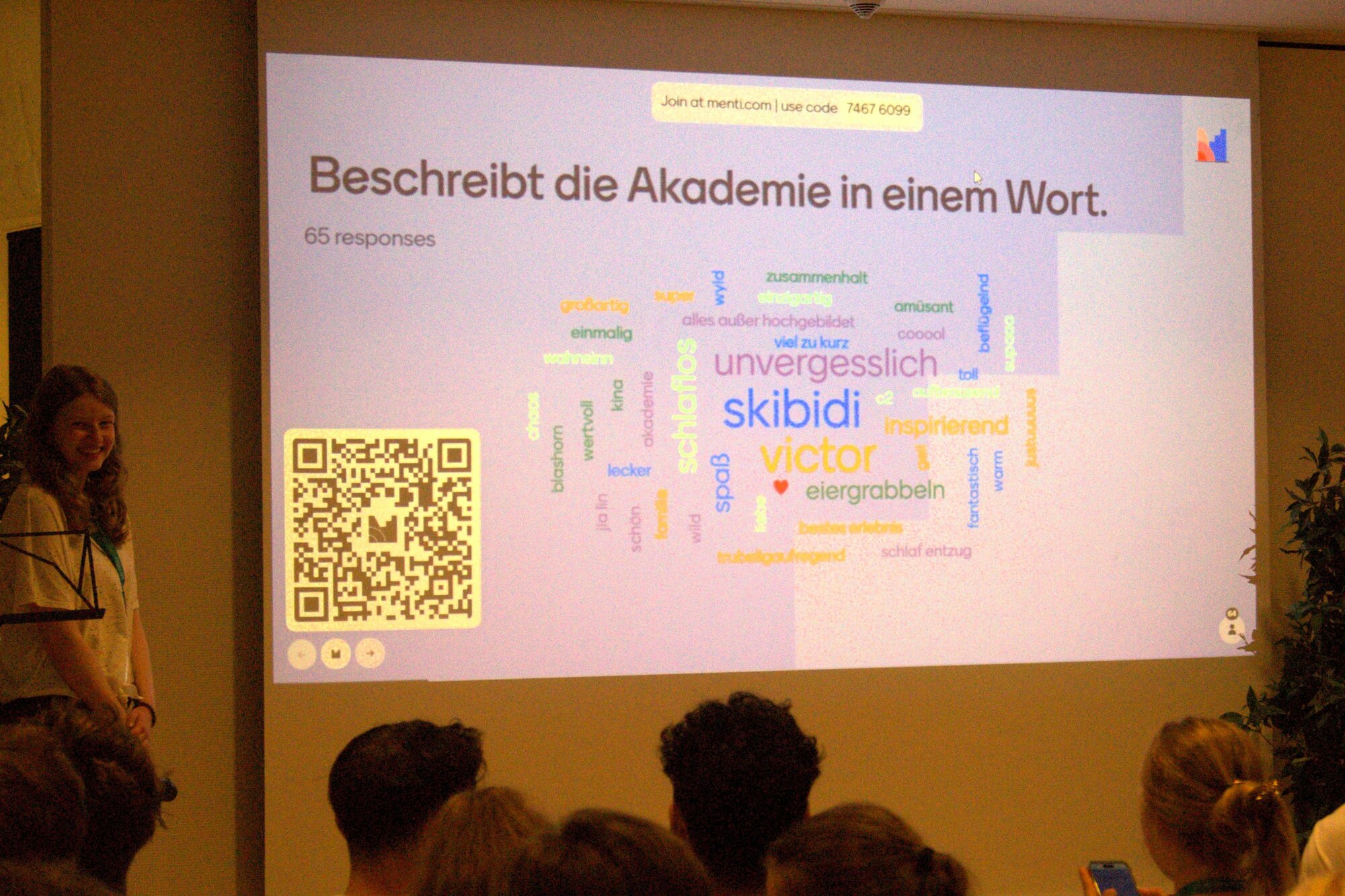 Die Ergebnisse einer Umfrage werden mit einem Beamer an die Wand projiziert. Im Vordergrund sind die Hinterköpfe der zuschauenden Schüler:innen zu sehen.